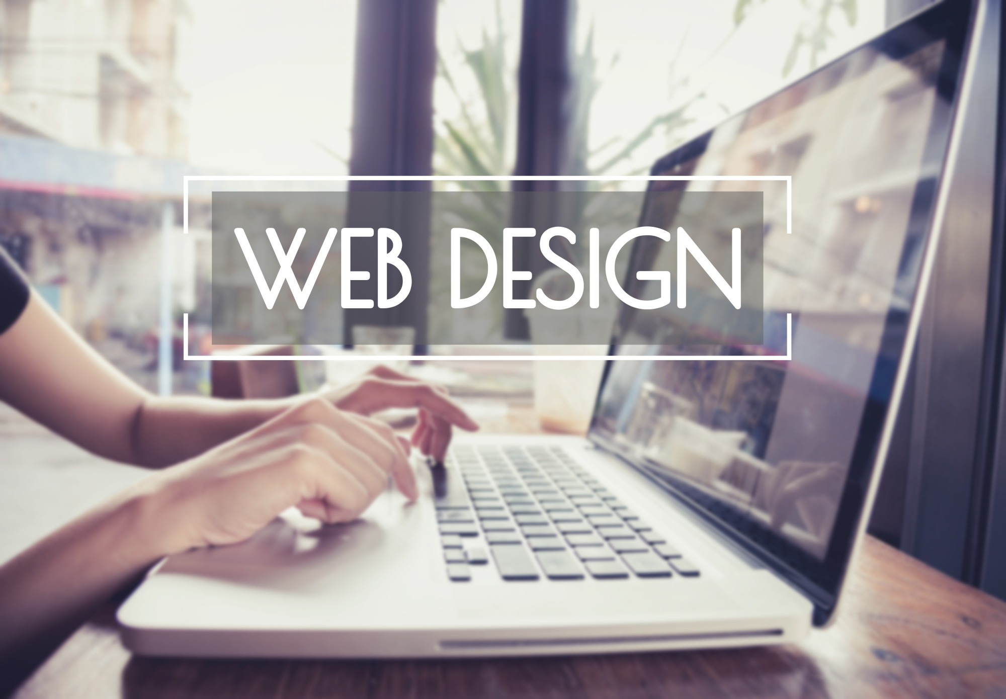 Business hand typing on a laptop keyboard with web design homepage on the computer screen website homepage ideas concept.